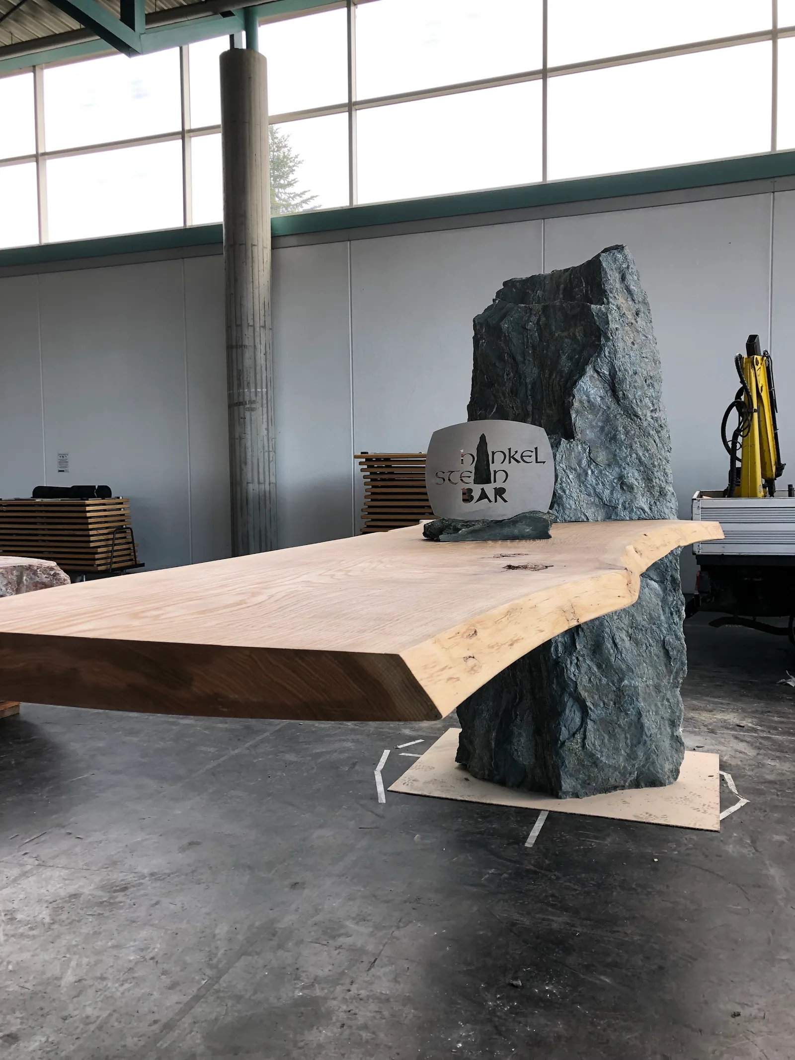 Steintisch mit massiven Natursteinwangen in der Werkhalle